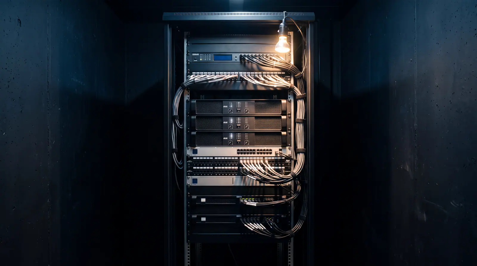 Design concept: a professional audio equipment rack with amplifiers, processing, and network hardware installed and cabling neatly dressed and labeled.