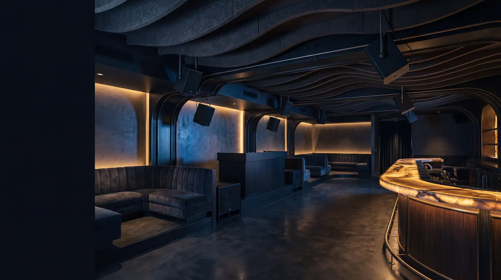 Design concept: an empty nightclub lounge before opening with compact loudspeakers flown discreetly from the ceiling structure and subwoofers built into the booth plinths.